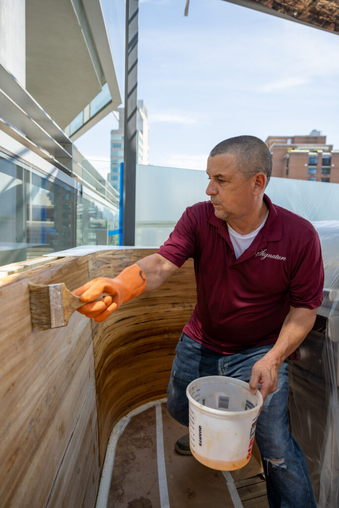 Signature Metal employee working on Wood restoration and maintenance on building rooftop in New York