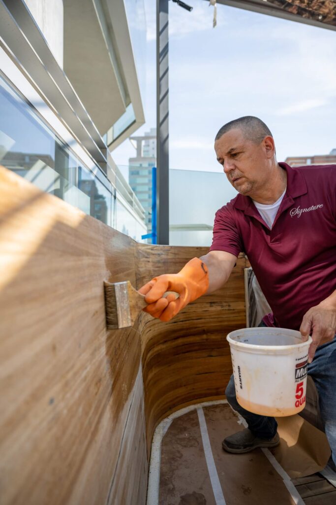 Man in Signature Metal shirt working on wood maintenance on rooftop of NYC building